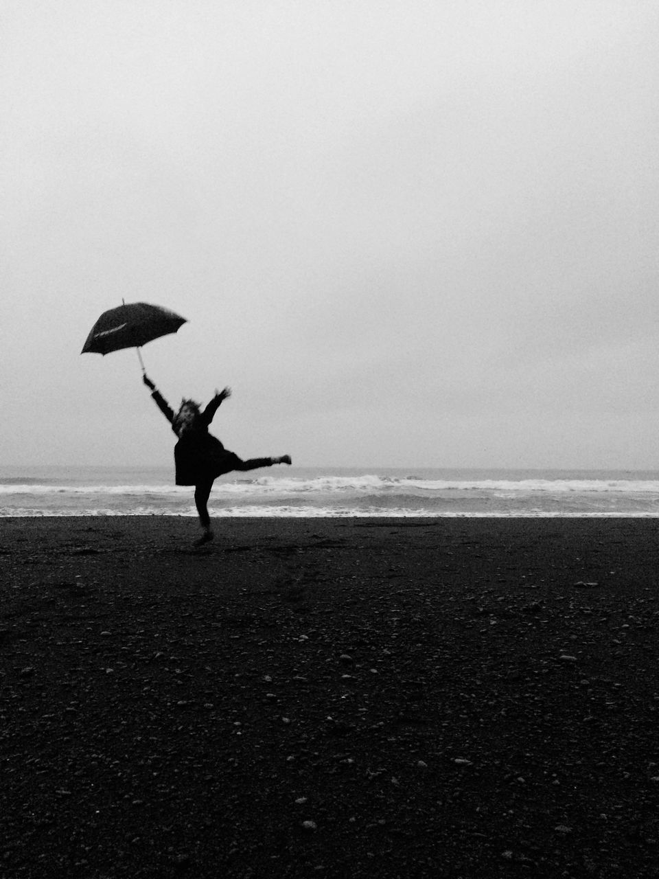 water, sea, black, beach, sky, horizon over water, black and white, land, horizon, nature, one person, monochrome, ocean, white, monochrome photography, full length, coast, silhouette, wind, umbrella, beauty in nature, leisure activity, scenics - nature, day, tranquility, adult, wave, outdoors, tranquil scene, lifestyles, motion, copy space, holiday, vacation, sand, trip, animal