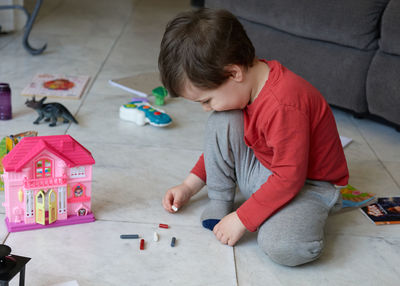 Cute young boy playing with toys in the livingroom