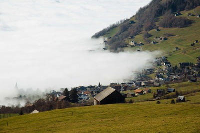 Scenic view of an alpine village surrounded by incoming fog