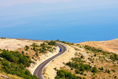 High angle view of road amidst mountains against blue sky