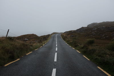 Road amidst mountains against clear sky