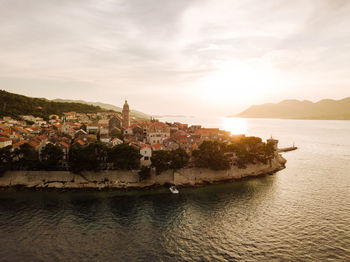 Aerial view of korcula old town in croatia at golden hour sunset with surrounding seascape.