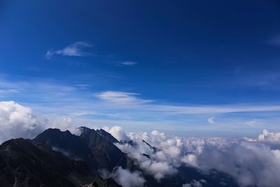 Scenic view of mountains against blue sky