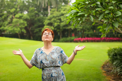 Woman gesturing while standing at park