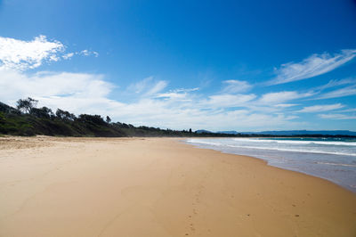 Scenic view of beach against blue sky