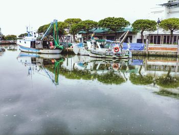 Boats moored in lake against sky