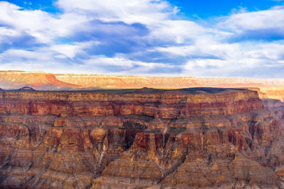 Rock formations on landscape against cloudy sky