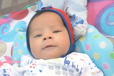 Portrait of cute baby lying on bed