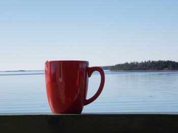 Close-up of coffee cup on table against clear sky