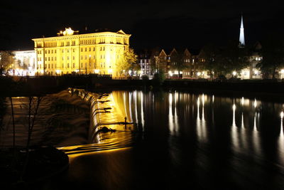 Reflection of buildings in river at night