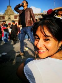 Portrait of smiling young woman against metropolitan cathedral