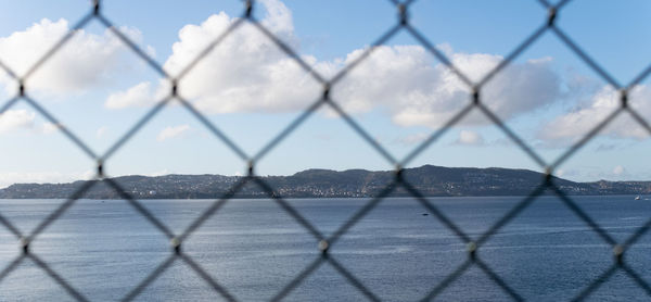 Full frame shot of chainlink fence against sky