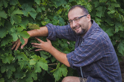 Portrait of man lying down by plants