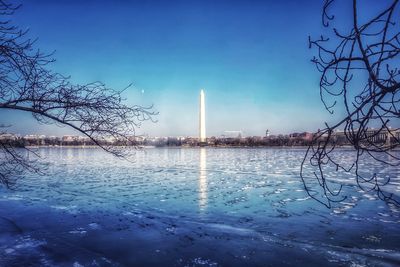 Scenic view of lake against blue sky during winter