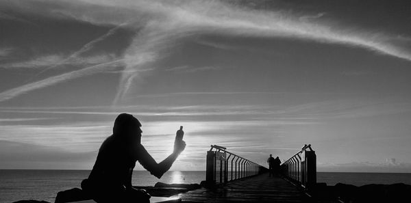 Women on sea shore against sky