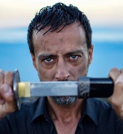 Close-up portrait of man holding camera