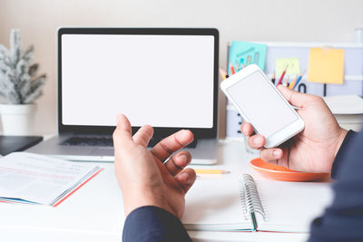 Midsection of man using laptop on table