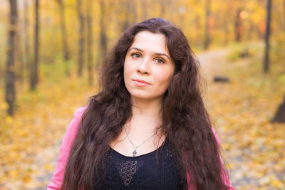 Portrait of beautiful young woman in forest during autumn