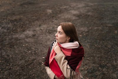 Young woman looking away standing outdoors