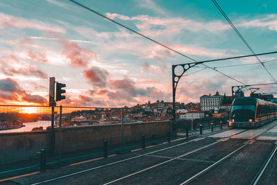Train at railroad station against sky during sunset