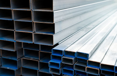 Industrial warehouse stock of rectangular metal pipes for building and construction supplies.