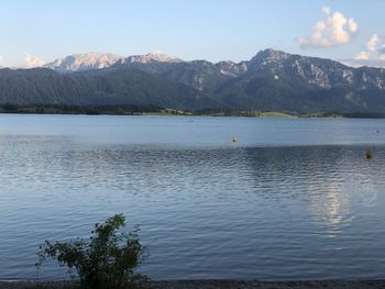 Scenic view of lake by mountains against sky