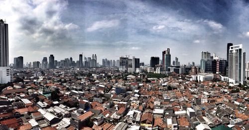 Cityscape against cloudy sky