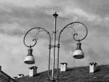 Low angle view of street light over house roof