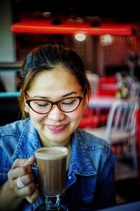 Portrait of woman drinking coffee in restaurant