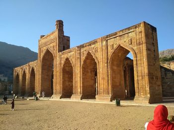 Tourists at historical building against clear sky