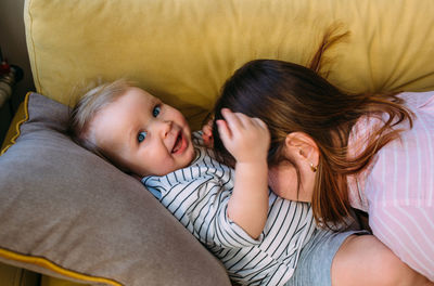 Mom plays at home with a small child on the couch, have fun.