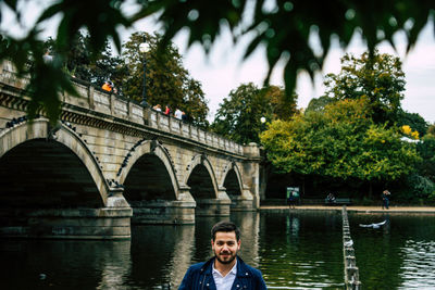 Portrait of man on bridge over river