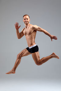 Low angle view of man exercising against white background