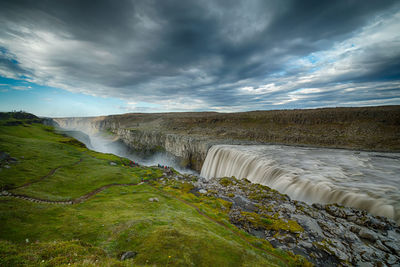 Scenic view of waterfall against sky