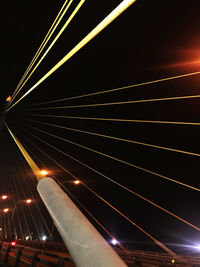 Low angle view of illuminated bridge against sky at night