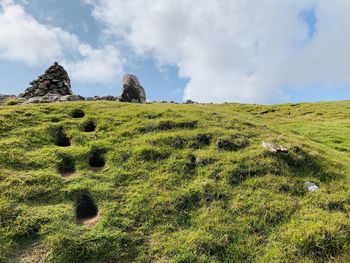 Scenic view of rocks on field against sky