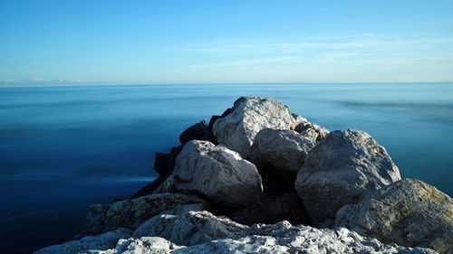 Rocks by sea against sky