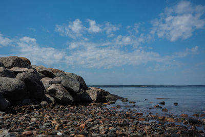 Rocks on sea shore against sky