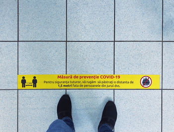 Low section of man standing on tiled floor