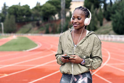 Smiling young woman using mobile phone