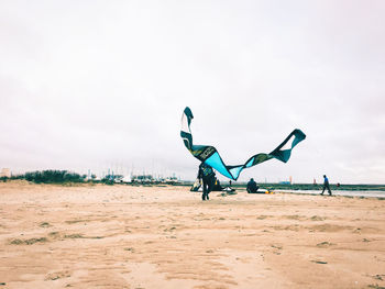 People sculpture on beach against sky