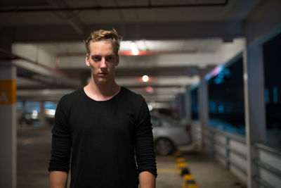 Portrait of young man standing at railroad station