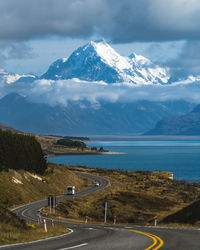 Winding road leading to snow capped mountain, mount cook, new zealand