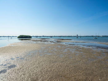 Scenic view of beach against clear blue sky