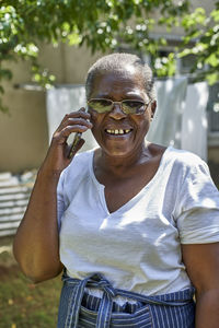 Smiling senior woman talking on the phone outdoors