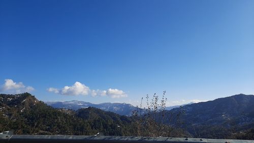 Scenic view of snowcapped mountains against blue sky