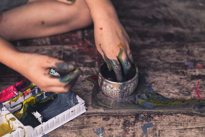 Cropped image of messy person with paint on hardwood floor