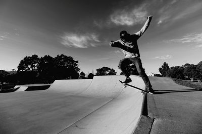 Man skateboarding on skateboard against sky