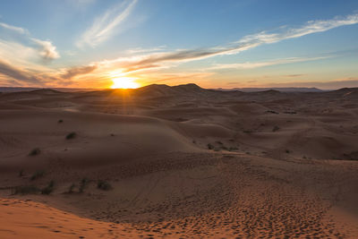 Scenic view of desert against sky during sunset