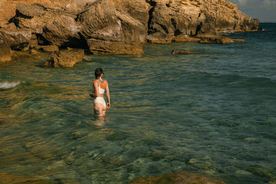 Full length of shirtless man in sea